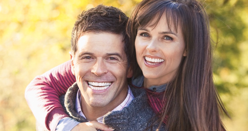 Portrait Of Two Happy Couples Facing Towards The Camera And Smiling