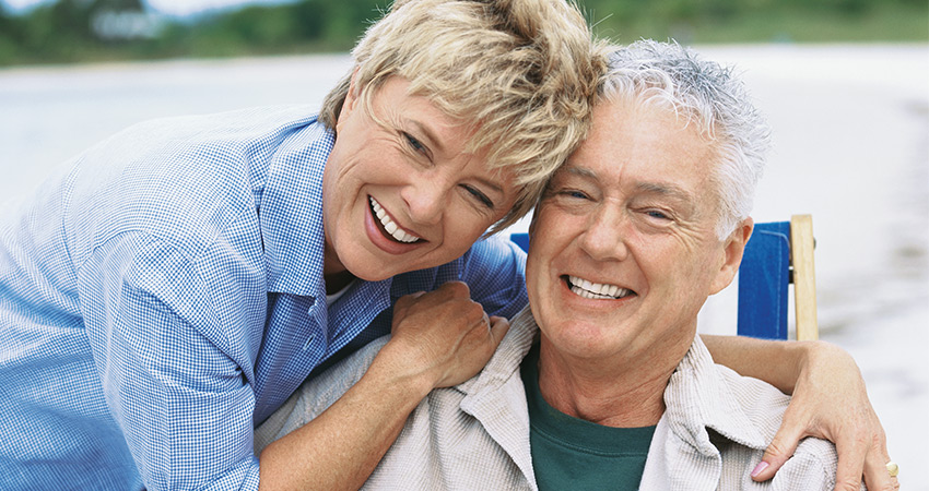 an older couple laughing with beautiful, complete smiles