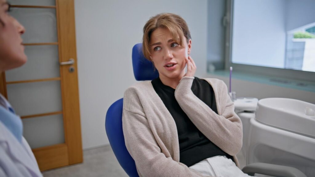 patient with tooth pain consulting emergency dentist in clinic