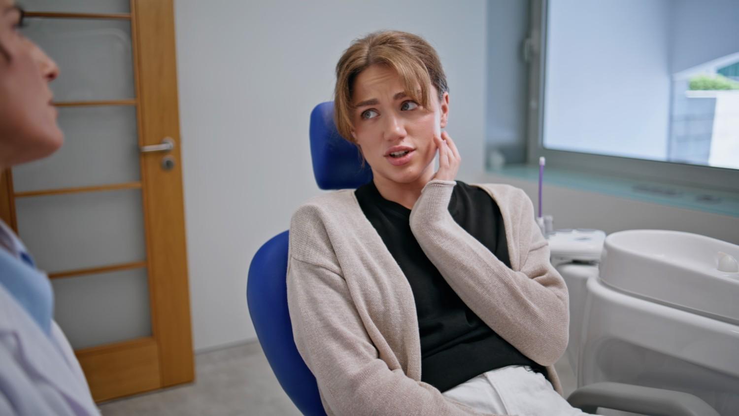patient with tooth pain consulting emergency dentist in clinic