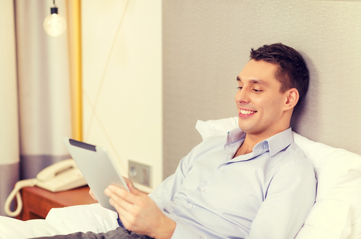 business-technology-internet-hotel-concept-happy-businessman-with-tablet-pc-computer-lying-hotel-bed