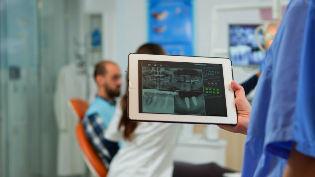 Dentist reviewing dental X-rays on a tablet