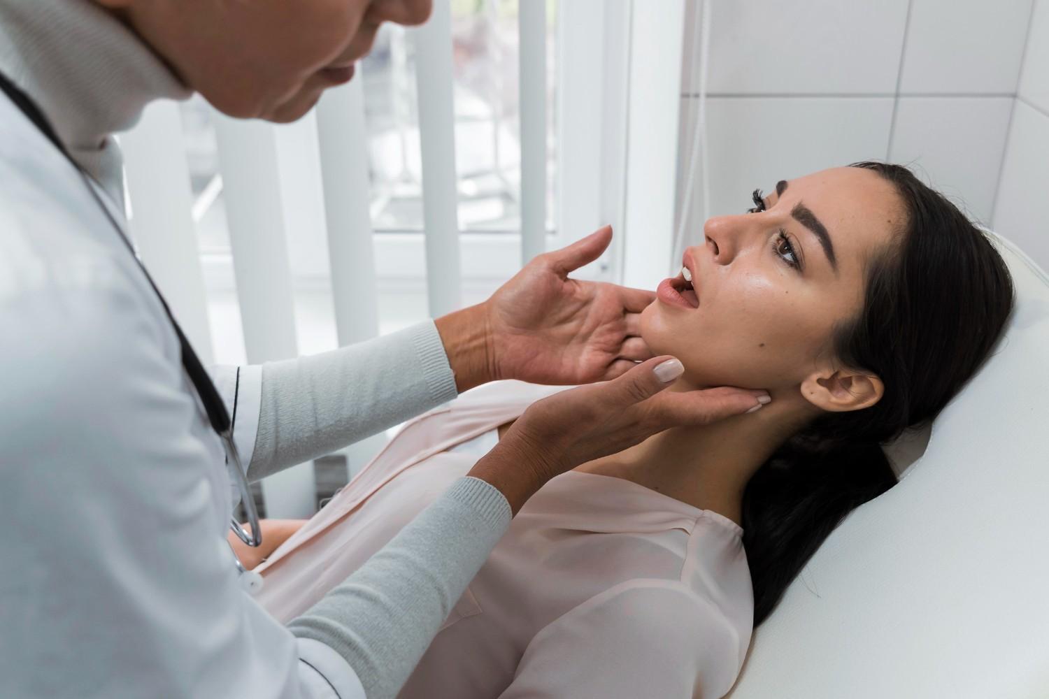 Dental professional examining a woman’s jaw