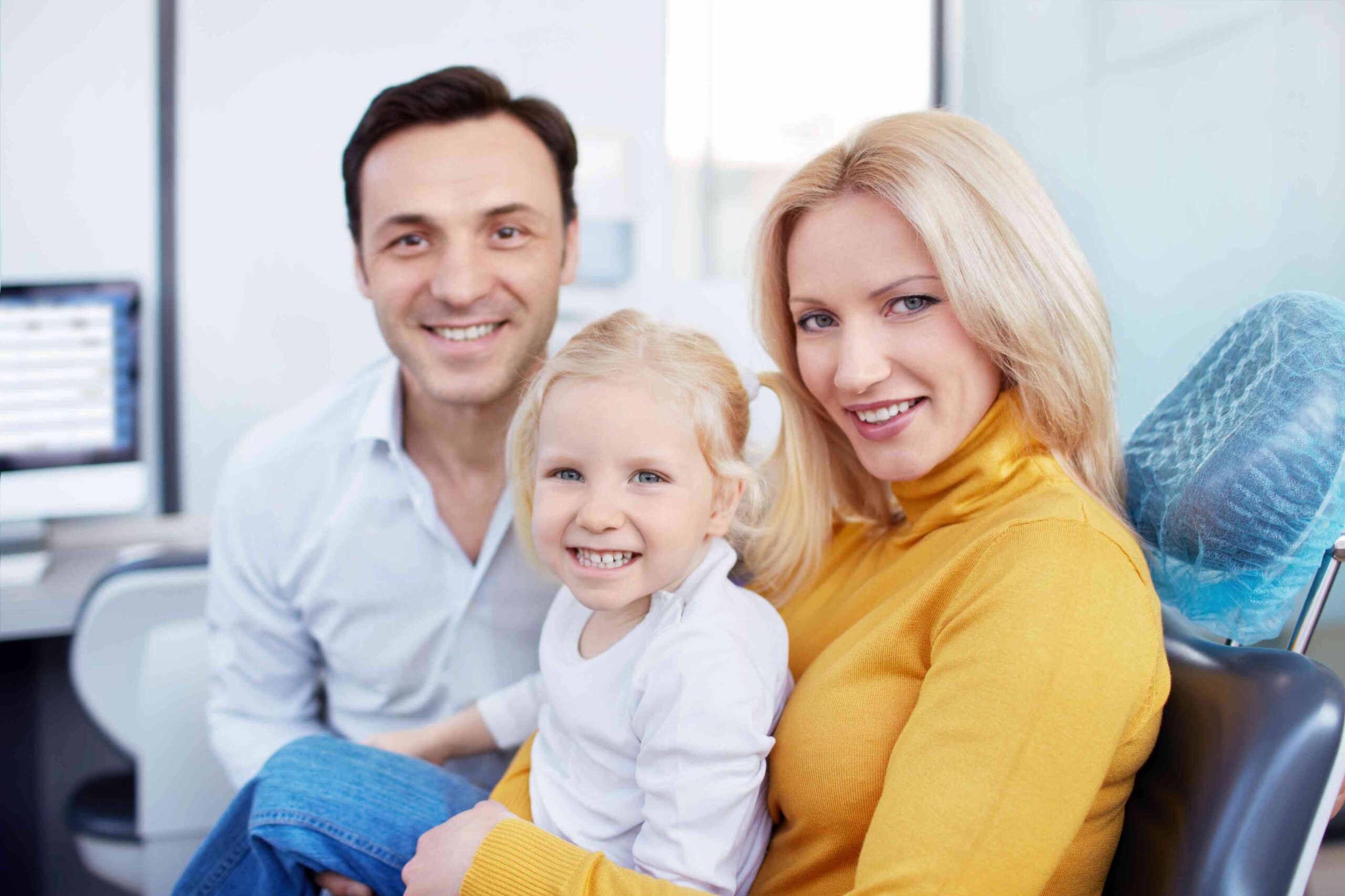 Happy family smiling at a dental office.