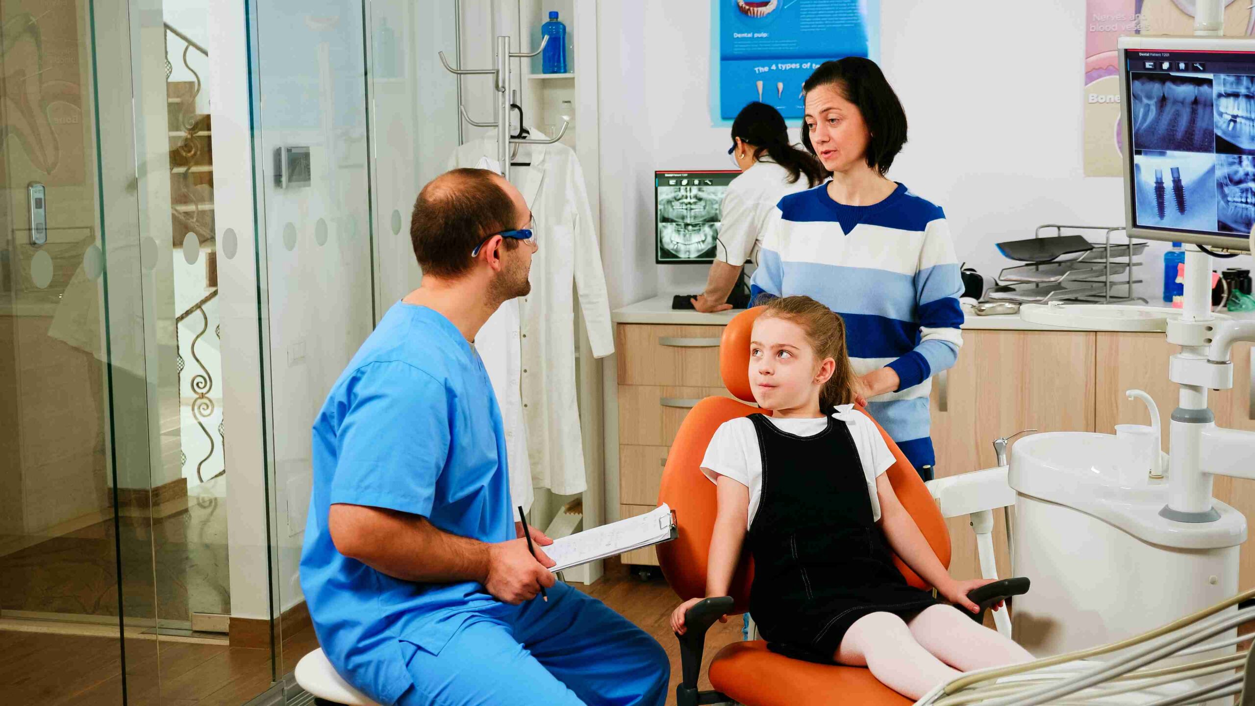 Dentist talking with a child and parent.